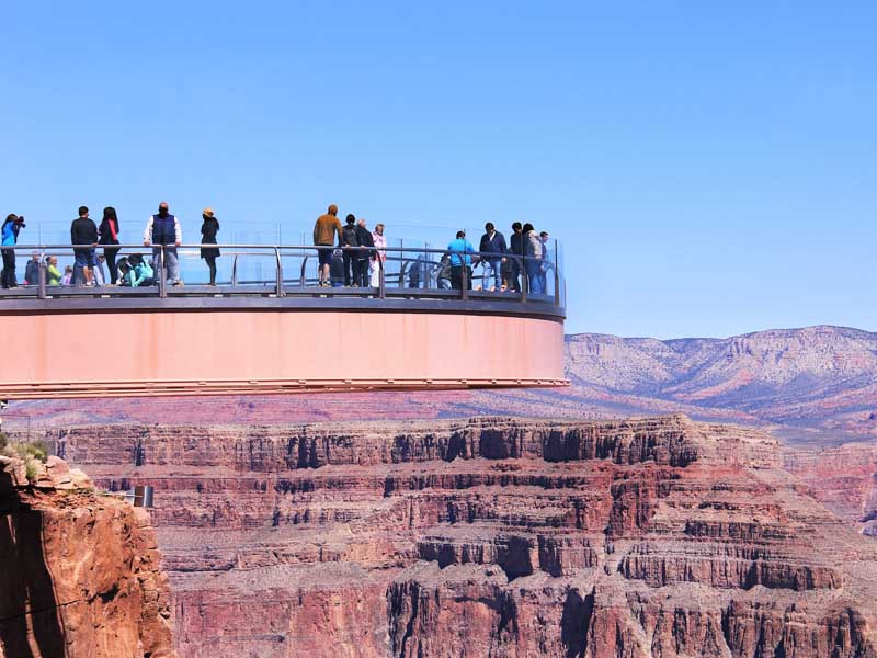 A group of people standing on the Grand Canyon West Glass Skywalk